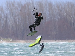 A kitesurfer flies past a foil boarder as strong winds hit the shore of Lake Ontario at Cherry Beach in Toronto, Ontario, Canada April 15, 2022.