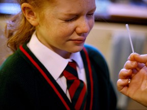 A girl takes a COVID-19 lateral flow self test ahead of returning to school, amid the COVID-19 outbreak in Manchester, Britain, Jan. 4, 2022.