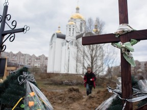 Kreuze werden am 4. April 2022 in Bucha, Ukraine, an einem Massengrab in der Nähe einer Kirche gesehen.