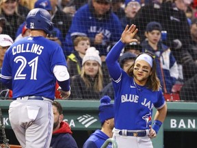 Blue Jays' Zack Collins returns to the dugout after hitting a solo home run in the second inning against the Red Sox at Fenway Park in Boston, Tuesday, April 19, 2022.
