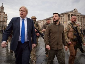 A handout photo released by the Ukrainian Presidential Press Service shows British Prime Minister Boris Johnson (left) and Ukrainian President Volodymyr Zelensky (centre) walking in central Kyiv, Saturday, April 9, 2022.