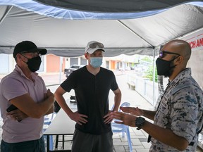 Alistair Godfrey (left), the father of the boyfriend of missing French diver Alexia Alexandra Molina, and Shaun Alexander (middle), friend of missing British diver Adrian Peter Chesters, are given a briefing during the search to locate three missing divers off Malaysia's southeast coast, in Mersing in Johor state on April 8, 2022.