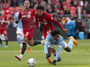 New York City FC's Talles Magno, right, goes down in the penalty area under a challenge from Toronto FC's Kosi Thompson, centre, during first half MLS soccer action in Toronto, Saturday, April 2, 2022.