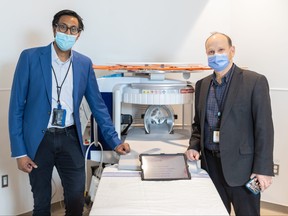 Dr. Aditya Bharatha, left, and Dr. Tim Dowdell pose with an example of the Hyperfine Swoop MRI machine in an undated handout photo.
