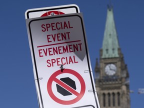 A temporary no-stopping sign is fixed with paper clips to a road sign near Parliament Hill, Thursday, April 28, 2022 in Ottawa.