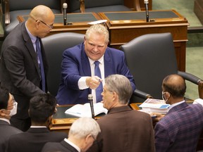 Ontario Premier Doug Ford signs copies of the budget for MPPs after Peter Bethlenfalvy, Ontario's Minister of Finance, delivers the provincial government's 2022 budget at the Queen's Park legislature, in Toronto, on Thursday, April 28, 2022.