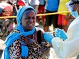 A young woman reacts as a health worker injects her with the Ebola vaccine, in Goma, Democratic Republic of Congo, Aug. 5, 2019.