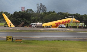 Feuerwehrleute arbeiten an der Stelle, an der ein Frachtflugzeug vom Typ Boeing 757-200, das von DHL betrieben wird, eine Notlandung durchführte, bevor es von der Landebahn rutschte und sich teilte, teilten die Luftfahrtbehörden mit, am 7. April 2022 auf dem internationalen Flughafen Juan Santamaria in Alajuela, Costa Rica.