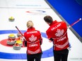 Jocelyn Peterman and Brett Gallant of Canada ponder their next move at the World Mixed Doubles Curling Championship 2022, Geneva, Switzerland.