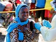 A young woman reacts as a health worker injects her with the Ebola vaccine, in Goma, Democratic Republic of Congo, Aug. 5, 2019.