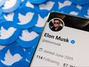 Das Twitter-Profil von Elon Musk ist auf diesem Bild, das am 28. April 2022 aufgenommen wurde, auf einem Smartphone zu sehen, das auf gedruckten Twitter-Logos platziert ist.