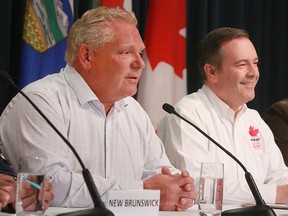 Ontario Premier Doug Ford speaks to media while Alberta Premier Jason Kenney looks on. The Premiers were in Calgary for the annual Premier's Stampede pancake breakfast held at McDougall Centr.  Monday, July 8, 2019. Dean Pilling/Postmedia