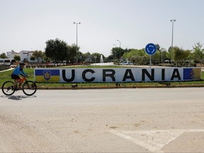 A cyclist rides past a sign in a roundabout that reads 'Ukraine' after it was changed from the original name of the town, as other street names were also changed to include names of Ukrainian cities in support of Ukraine, amid Russia's invasion, in the town of Fuentes de Andalucia, near Seville, southern Spain, April 16, 2022.
