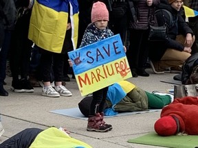 A little girl with a "Save Mariupal" sign was among the pro-Ukraine demonstators who turned up Sunday at City Hall.