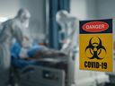 A patient is treated in a room with a COVID warning sign at a hospital.