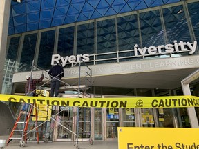 Crews work to remove Ryerson University signage after the school was renamed Toronto Metropolitan University.