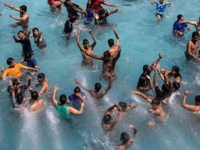 People cool off in a wave pool during a hot summer day at a water park in New Delhi, Saturday, April 30, 2022.