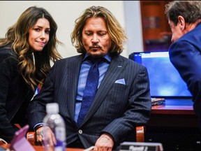 Actor Johnny Depp listens to his legal team during his defamation case against ex-wife Amber Heard at the Fairfax County Circuit Court in Fairfax, Va., April 14, 2022.