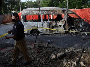 Police adjusts crime scene barricade tape at the blast site a day after a suicide attack on a van near the Confucius institute which is the cultural programme that China operates at universities around the world at the Karachi University in Karachi on April 27, 2022.