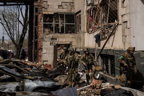 Ukrainian soldiers walk among debris following Russian shelling, as Russia’s attack on Ukraine continues, in Kharkiv, April 16, 2022.