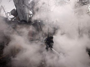A firefighter works to extinguish a fire at a warehouse caused by recent Russian shelling on April 14, 2022 in Kharkiv, Ukraine.