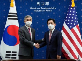 U.S. Special Representative for North Korea Sung Kim (left) shakes hands with South Korea's Special Representative for Korean Peninsula Peace and Security Affairs Noh Kyu-duk (right) during their meeting at the Foreign Ministry in Seoul on April 18, 2022.
