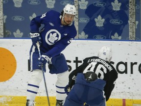 Maple Leafs Auston Matthews dishes off a puck past  Ilya Lyubushkin during practice on Friday.