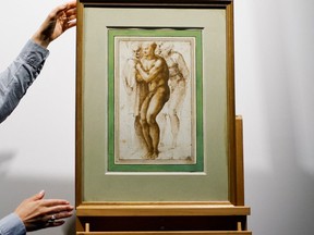 A Christie's employee installs the drawing "A nude young man (after Masaccio) surrounded by two figures" by Michelangelo Buonarroti (1475-1564) before its auction at Christie's auction house in Paris, April 5, 2022.