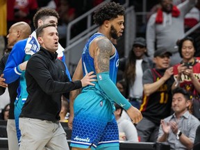 Hornets forward Miles Bridges (right) is restrained after being called for a technical foul and being ejected from the game against the Hawks during the second half at State Farm Arena in Atlanta, Wednesday, April 13, 2022.