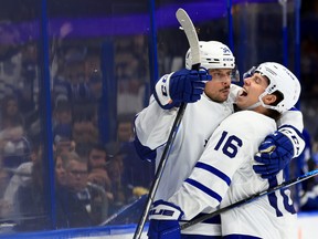 Maple Leafs' Auston Matthews (left) celebrates his hat-trick goal with teammate Mitch Marner during the third period against the Tampa Bay Lightning at Amalie Arena Monday, April 4, 2022 in Tampa, Fla.