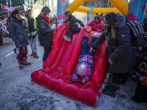 In this photo taken on Feb. 5, 2022, children play in a blow-up play area on Ottawa's Wellington Street during the Freedom Convoy, which drew thousands to protest against COVID-19 mandates.