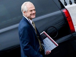 Former White House advisor Peter Navarro leaves the West Wing carrying a poster board displaying claims of voting irregularity at the White House in Washington, D.C., Jan. 15, 2021.