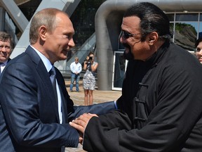 This file photo taken on September 4, 2015 shows Russian President Vladimir Putin, left, shaking hands with U.S. actor Steven Seagal in Vladivostok.