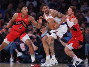 New York Knicks' Obi Toppin secures the ball as Raptors' Scottie Barnes (left) and Malachi Flynn (right) defend during the first half at Madison Square Garden on Sunday, April 10, 2022.