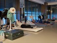 Community workers browse their mobile phone on temporary beds at a gym in a compound during a COVID-19 lockdown in Pudong district in Shanghai on April 13, 2022.