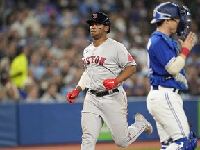Boston Red Sox third baseman Rafael Devers (left) scores against the Toronto Blue Jays during the sixth inning at Rogers Centre on Wednesday, April 27.