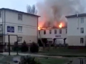 Flames engulf a building following a bombing at a hospital in Lyman, Donetsk region, Ukraine April 22, 2022, in this still image obtained from a social media video.