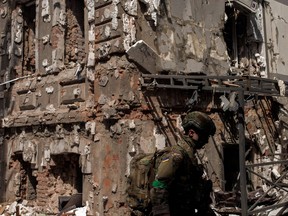A Ukrainian soldier walks next to a destroyed building following Russian shelling, as Russia's attack on Ukraine continues, in Kharkiv, April 16, 2022.