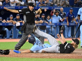 Home plate umpire James Hoye signals that Toronto Blue Jays pinch runer Breyvic Valera is safe at home after a wild pitch by Chicago White Sox relief pitcher Craig Kimbrel in the eighth inning at Rogers Centre in Toronto, Aug. 23, 2021.