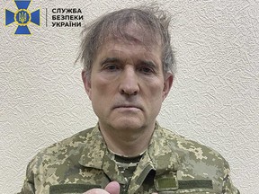 This undated and unlocated handout picture released on April 12, 2022 by the Security Service of Ukraine shows business tycoon Viktor Medvedchuk with his hands in cuffs and dressed in a Ukrainian army uniform.