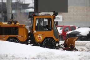 Snow plows begin clearing streets and sidewalks during a break in a snowstorm in Winnipeg, April 13, 2022.