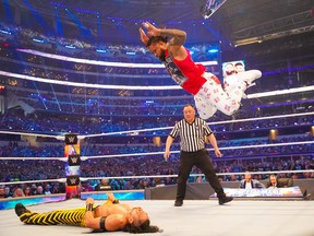 Jimmy Uso performs an Uso Splash on Shinsuke Nakamura during the opening match of WrestleMania last night in Arlington, Tex. Jimmy Uso and his twin brother Jey Uso defeated Nakamura and Rick Boogs to retain the SmackDown tag-team championship.