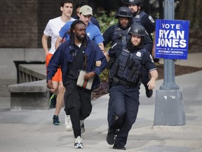 Metropolitan Police run as they escort people away from a shooting scene in the northwest part of Washington, D.C., Friday, April 22, 2022.