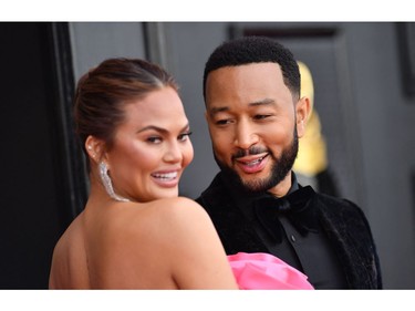 US model Chrissy Teigen (L) and US singer-songwriter John Legend arrive for the 64th Annual Grammy Awards at the MGM Grand Garden Arena in Las Vegas on April 3, 2022. (Photo by ANGELA WEISS / AFP)