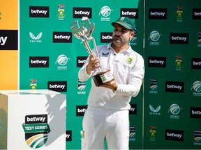 South Africa's captain Dean Elgar looks at the trophy after South Africa won the series following the second Test cricket match between South Africa and Bangladesh at St George's Park in Gqeberha on April 11, 2022.