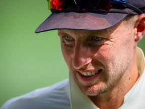 In this file photo taken on December 9, 2021 England's captain Joe Root smiles as he walks off at the tea interval during day two of the first Ashes cricket Test match between England and Australia at the Gabba in Brisbane.