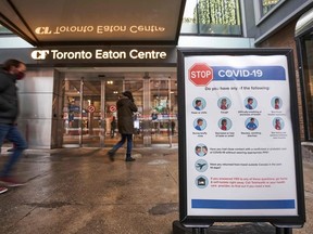 In this file photo people arrive at the entrance to the Toronto Eaton Centre in downtown Toronto, Ontario on November 23, 2020, the first day of a new lockdown in the city.