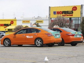 A couple of Beck cabs wait for fares at a No Frills in the Pharmacy-Eglinton Aves. area on   April 16, 2020.