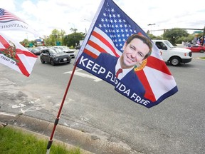 A flag with a photo of Florida Governor Ron DeSantis is where supporters of Florida's Republican-backed "Don't Say Gay" bill that bans classroom instruction on sexual orientation and gender identity for many young students gather for a rally outside Walt Disney World in Orlando, Florida, U.S. April 16, 2022.