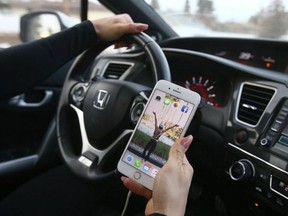 A driver checks her phone while behind the wheel.